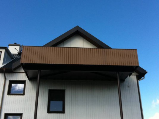 Mörkbrun fasadpanel monterad runt balkong